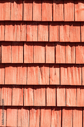 Red wood shingle on a sunny house wall