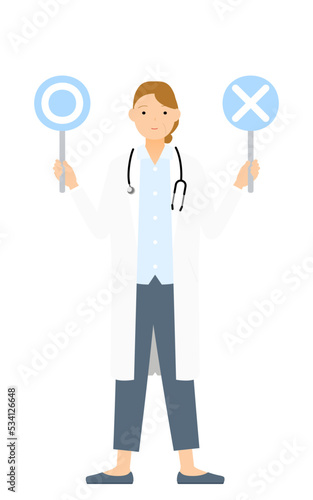 白衣のシニア女性医師がマルバツ棒を持つ・答え合わせのポーズ