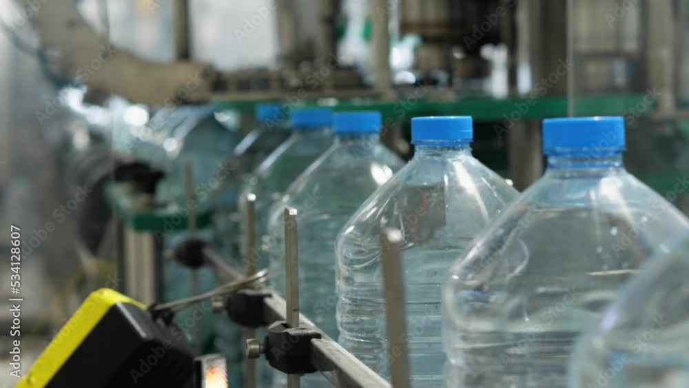 Full five-liter bottles move along the conveyor. Drinking water production line. Mineral Water Production Plant.Slow motion Full five-liter bottles move along the conveyor. Drinking water production line. Mineral Water Production Plant.Slow motion