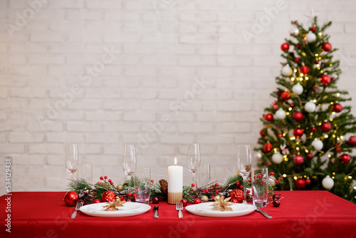 Served table for christmas dinner in decorated living room with copy space photo