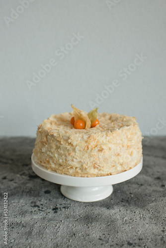 Layered cake on a plate decorated with physalis