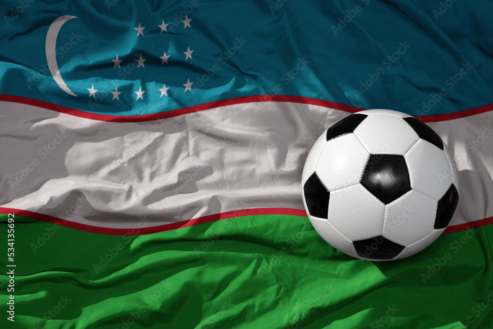 Naklejka premium vintage football ball on the waveing national flag of uzbekistan background. 3D illustration
