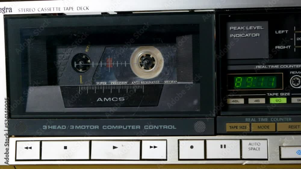 A man presses the stop button on a cassette recorder. Close-up playback of a vintage audio cassette. A man presses the stop button on a cassette recorder. Close-up playback of a vintage audio cassette.