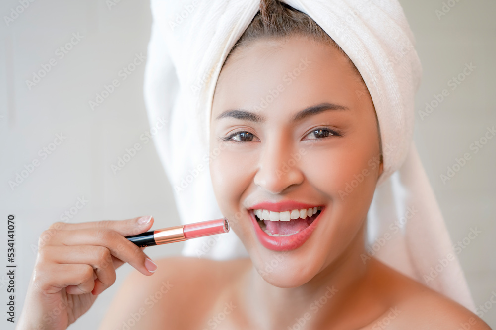Young Women in white towel showing lipstick. Young Women in white towel showing lipstick.