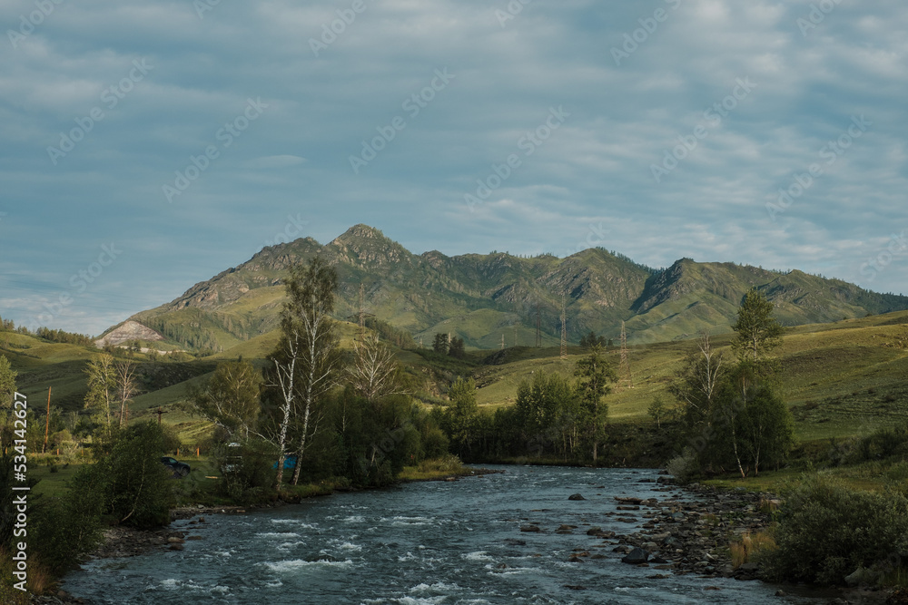 A beautiful Siberian landscape with a river against a background of mountains in the Altai Republic