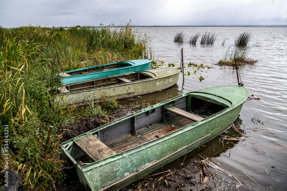 boats for fishing on the lake on a cloudy autumn day