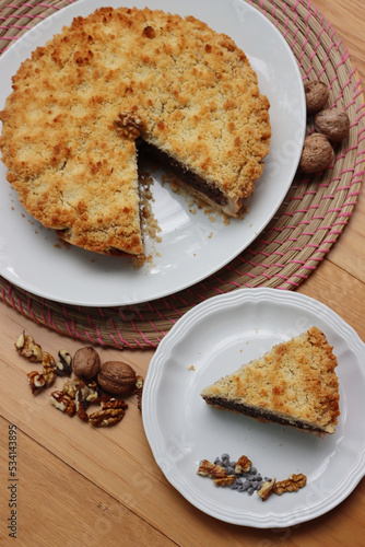 Traditional italian cake Sbrisolona cut in slices made with walnuts and chocolate on a plate on wooden table photo