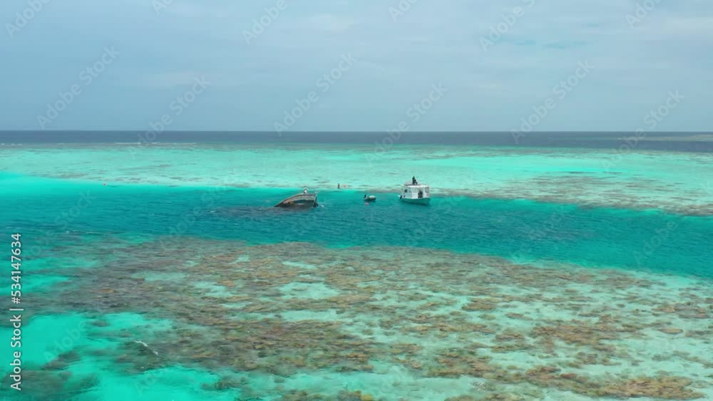 Aerial view on Shipwreck and Boats with tourists in Vaavu Atoll near Keyodhoo Island, Maldives. Aerial view on Shipwreck and Boats with tourists in Vaavu Atoll near Keyodhoo Island, Maldives.