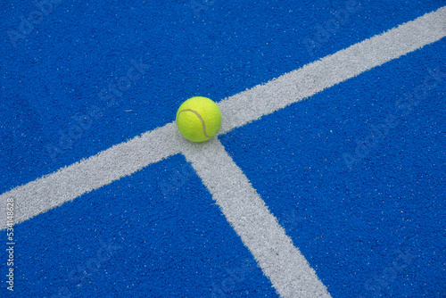 a ball on the line on a blue paddle tennis court © Vic