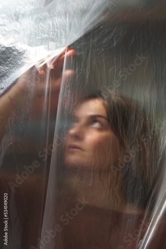 light portrait woman looking through plastic foil