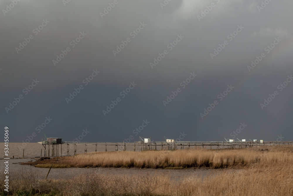 Fishing huts under stormy weather clouds Atlantic coast of Charente-Maritime, France