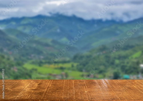 Fototapeta Naklejka Na Ścianę i Meble -  Wooden table top on blur rice field and mountain background in daytime.Harvest rice or whole wheat.For montage product display or design key visual layout.View of copy space.
