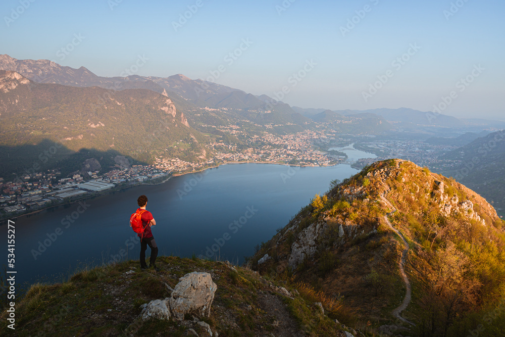 the alps, lakes and cities of brianza seen in the sunset light from the top of mount Barro, near the town of lecco, Italy - April 2022.