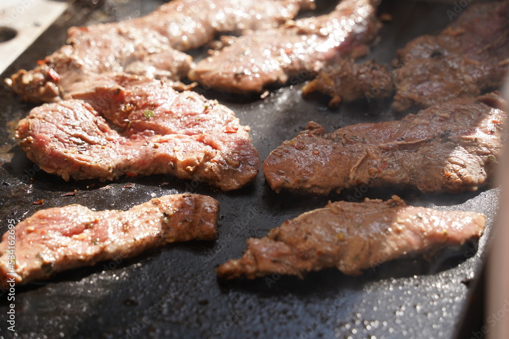 Roasting different pieces of beef for burgers and quesadillas.