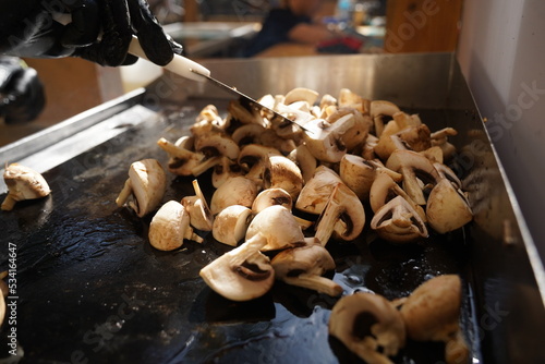 Roasting mushrooms on an open outdoor flat plate.