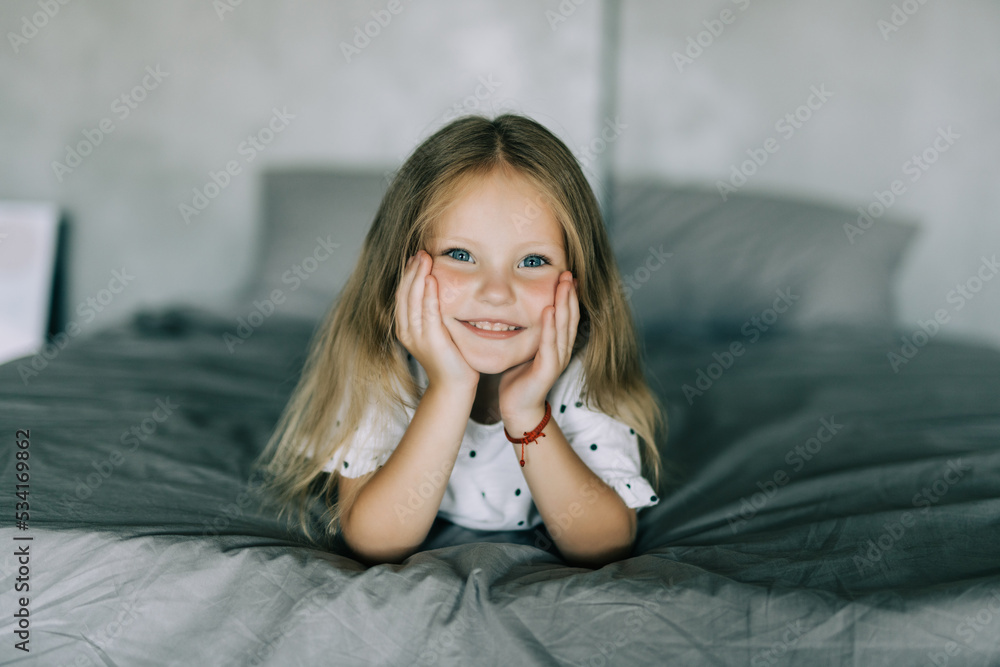 Portrait of cute girl lying in the bed