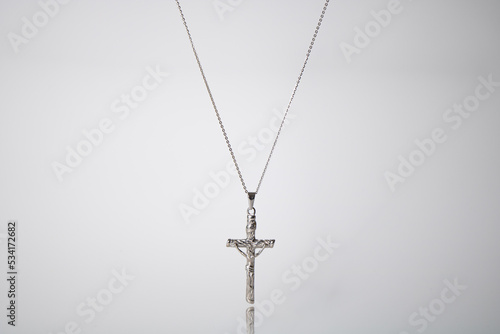 silver pendant with a chain against a white backdrop product picture adverstisement photo