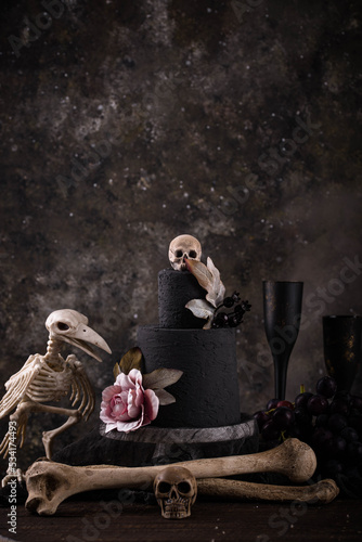 Halloween still life with skull, bones and cake