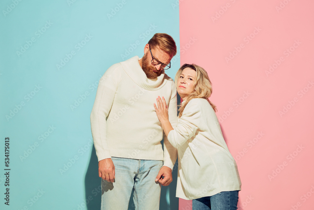 Support. Expressive young people, man and woman, husband and wife spending time together isolated over blue and pink background. Support. Expressive young people, man and woman, husband and wife spending time together isolated over blue and pink background.