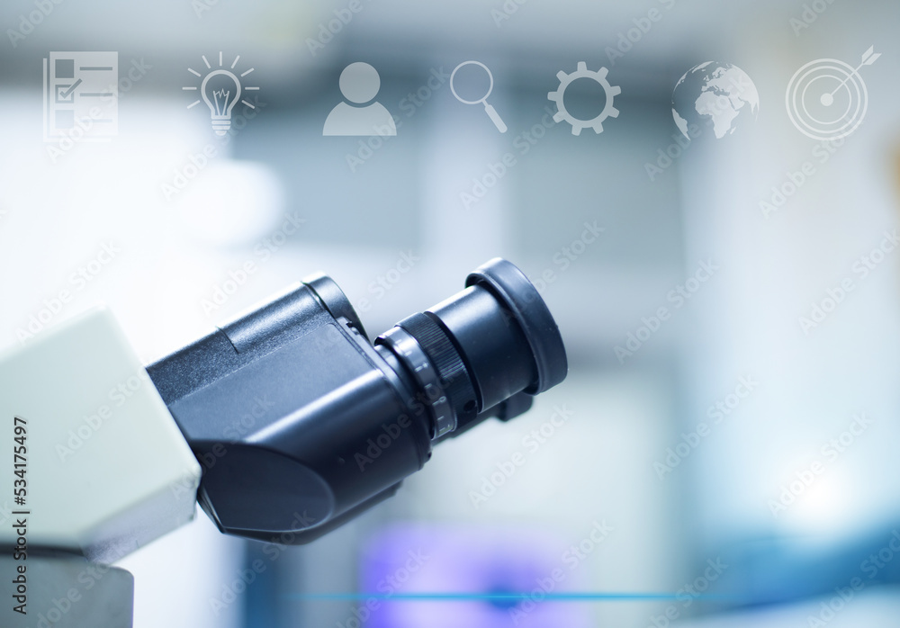 Naklejka premium Microscope in laboratory with tecnology background.