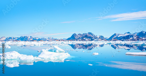 Panoramic view of colorful Kulusuk village in East Greenland - Kulusuk, Greenland - Melting of a iceberg and pouring water into the sea © muratart