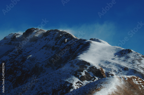 The mountain ridge at the Manina Pass (Passo della Manina), with the wind that raises the snow. Bergamasque Alps, Italy photo
