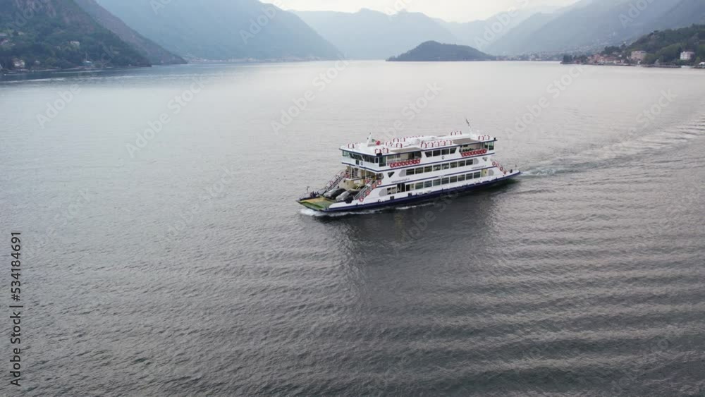 Ferry Boat Carrying Cars Sailing Across The Lake Como To Bellagio Comune in Italy. - aerial Ferry Boat Carrying Cars Sailing Across The Lake Como To Bellagio Comune in Italy. - aerial