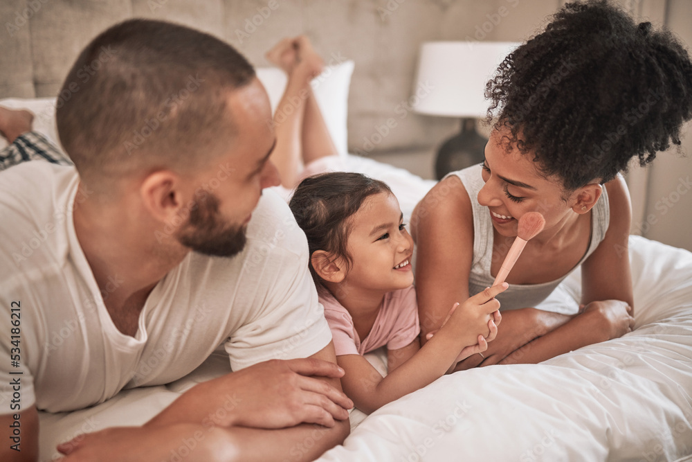 Cosmetics, relax and happy family on a bed with the child having fun with a makeup brush, laughing and playing. Mother, father and girl enjoy quality time together with beauty products in the morning Cosmetics, relax and happy family on a bed with the child having fun with a makeup brush, laughing and playing. Mother, father and girl enjoy quality time together with beauty products in the morning