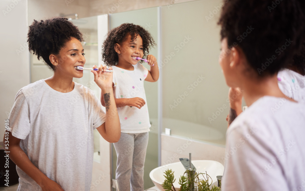 Fototapeta premium Mirror reflection of mom and girl brushing teeth together while bonding, having fun and enjoy quality time. Child development, learning or dental care for oral hygiene girl cleaning teeth in bathroom