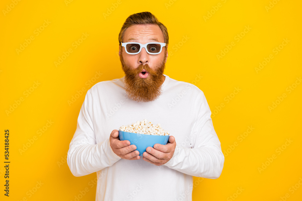 Photo of cool beard red hair man hold popcorn watch film wear eyewear white shirt isolated on yellow color background Photo of cool beard red hair man hold popcorn watch film wear eyewear white shirt isolated on yellow color background