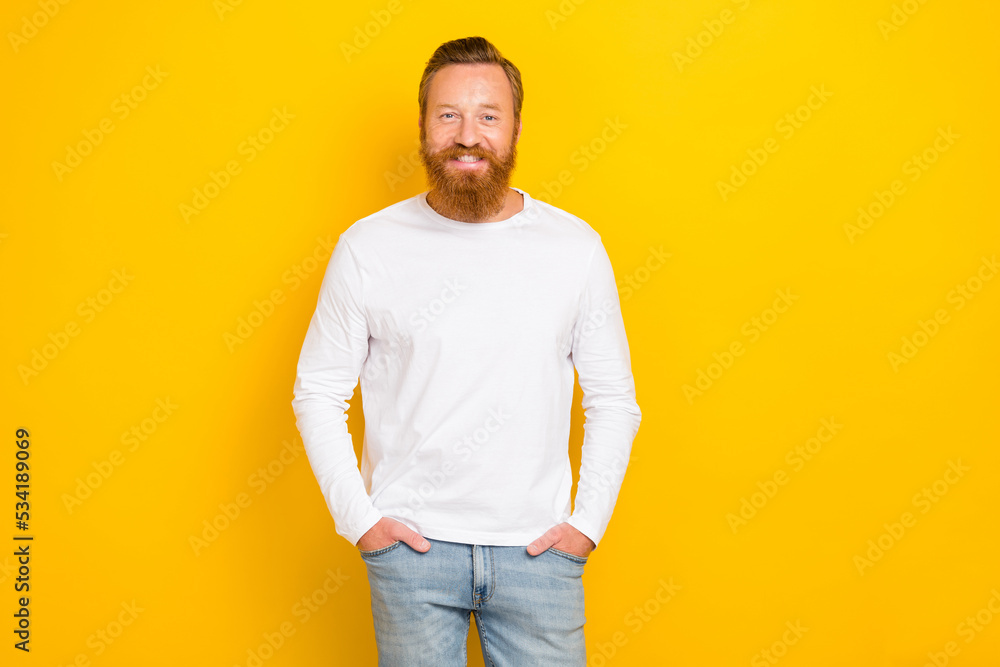 Photo of young handsome smiling confident guy hold hand pockets denim wear white pullover company owner isolated on yellow color background