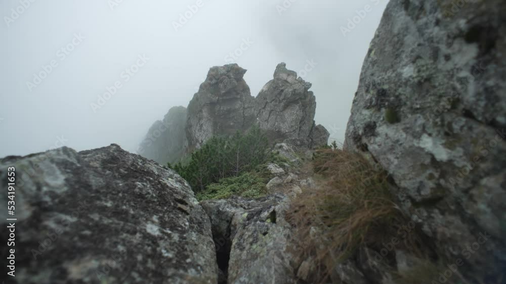 Beautiful landscape of mystical rocks in the mountains. The peaks and mountain ranges are covered in fog. Bad weather in nature. High quality 4k footage Beautiful landscape of mystical rocks in the mountains. The peaks and mountain ranges are covered in fog. Bad weather in nature. High quality 4k footage