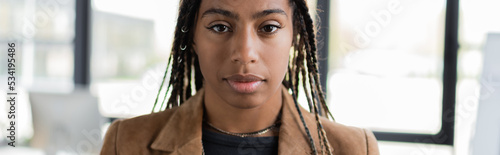 Portrait of african american businesswoman looking at camera in office, banner.