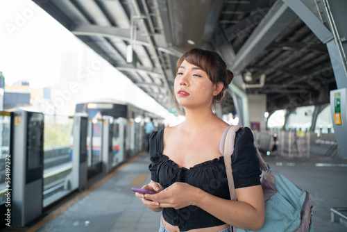 Beautiful asian woman use smartphone travel in city train