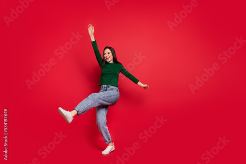 Full length photo of gorgeous relaxed lady raise arm leg dance chill party wear trendy green garment isolated on shine red color background