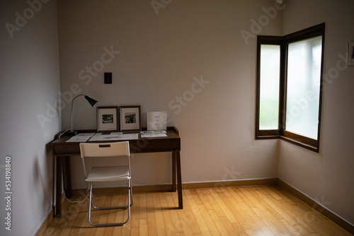 Desk and chair reflected in light in dark room