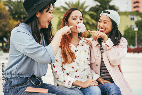 Photography Happy young asian girls having fun playing with bubble gum outdoor - Focus on le