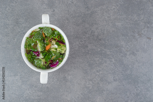 Bowl of vegetable soup on marble background