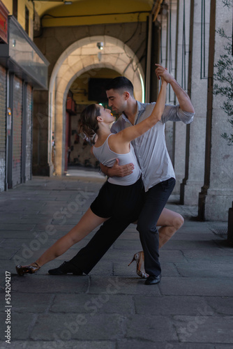 Tango dancing couple. Boy in a suit and shirt, girl in shorts and a t-shirt. dance, ballroom, argentinian