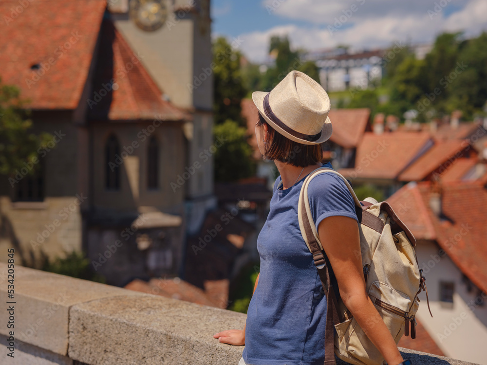 having great vacation in Switzerland, BErn. Lady visiting tourist attractions and landmarks. Woman tourist on top of cityscape view to old town of Bern