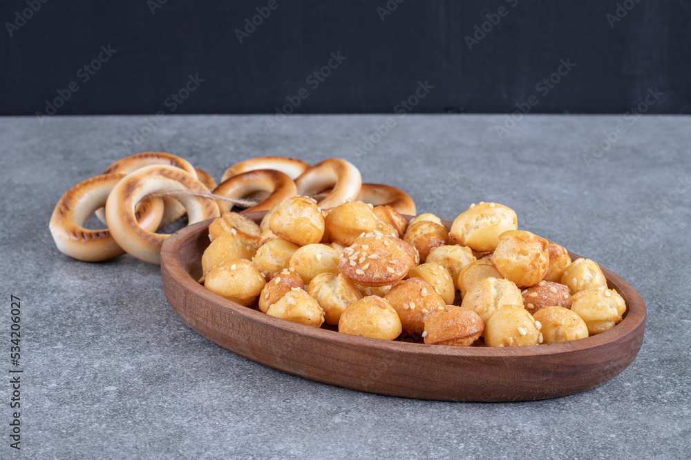 Fototapeta premium Round crackers and plate full of salty crackers on marble surface