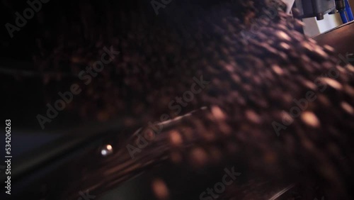 Coffee roaster machine mixing aroma beans.Preparation fresh aroma caffeine on manufacturing warehouse.Close-up Make ready coffee in large roaster falling beans