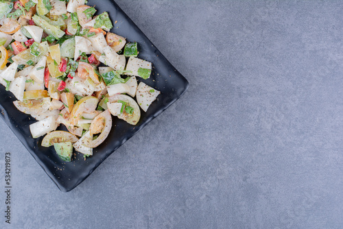 Salad with chopped herbs and vegetables on concrete background