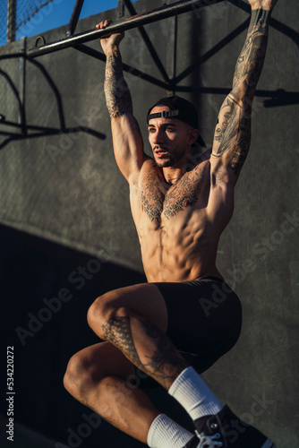 Chico joven musculado haciendo ejercicio y posando en gimnasio al aire libre en día soleado © MiguelAngelJunquera