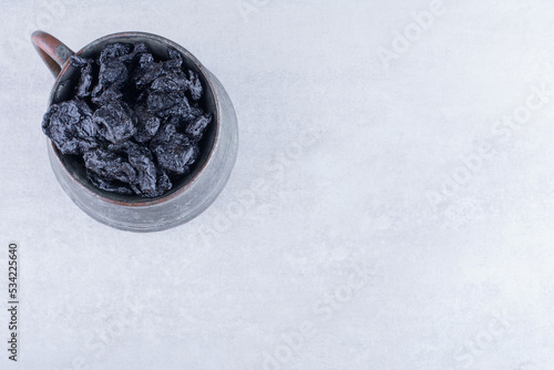 Black dried sultanas isolated on concrete background