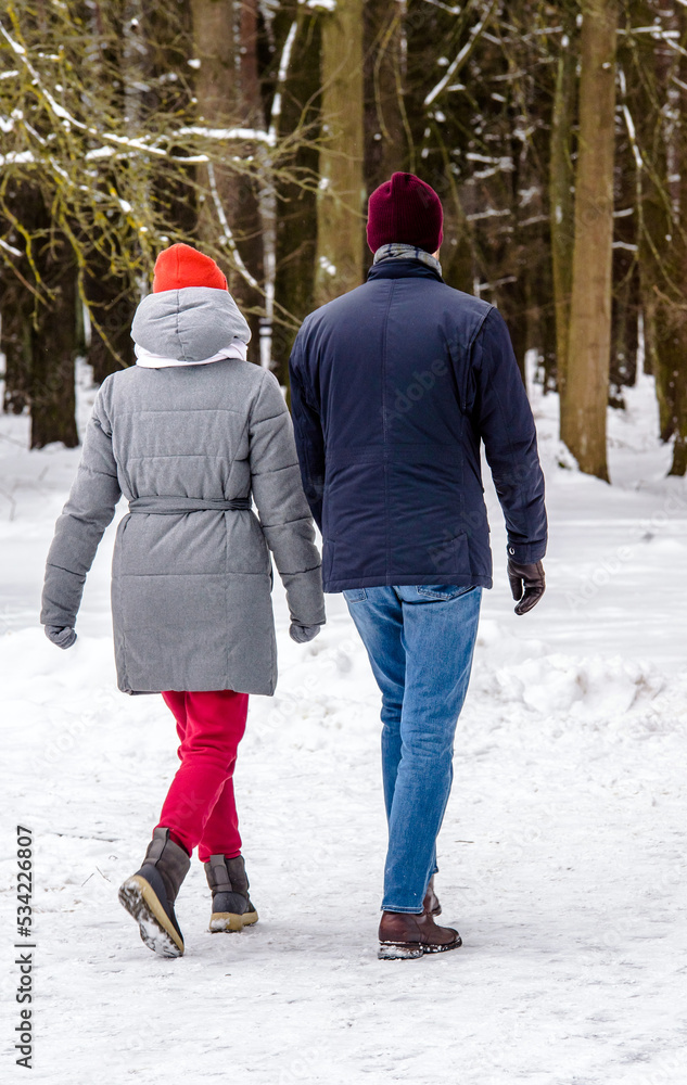  A guy and a girl walking in winter Park
