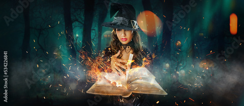 Photo Halloween Witch girl with magic Book of spells portrait