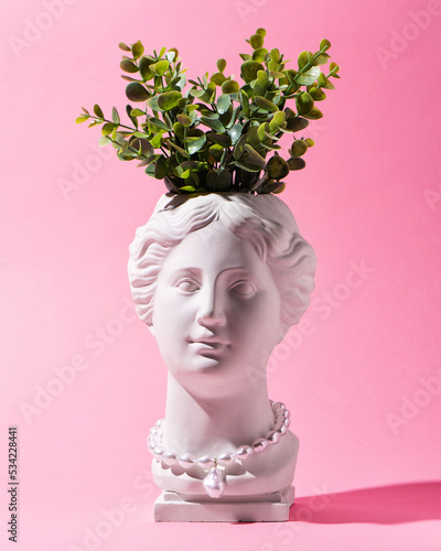 Fototapeta Naklejka Na Ścianę i Meble -  Trendy Venus plaster head planter pot with pearls jewelry on pink background. Neon colors