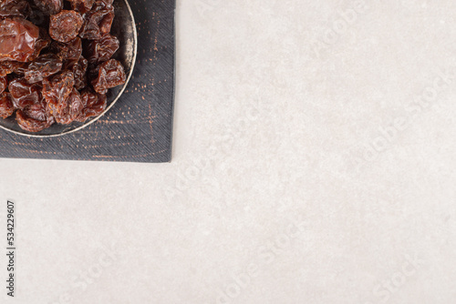 Dried brown cherries in a metallic cup