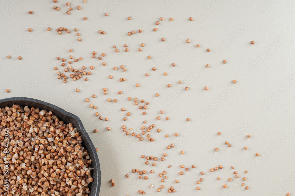Buckwheat seeds in a dish on concrete background Buckwheat seeds in a dish on concrete background